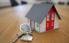 miniature white and red wooden house on a brown table
