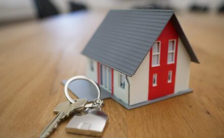 miniature white and red wooden house on a brown table