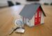 miniature white and red wooden house on a brown table