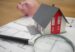 white and red wooden house beside a grey-framed magnifying glass
