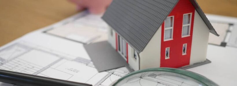 white and red wooden house beside a grey-framed magnifying glass